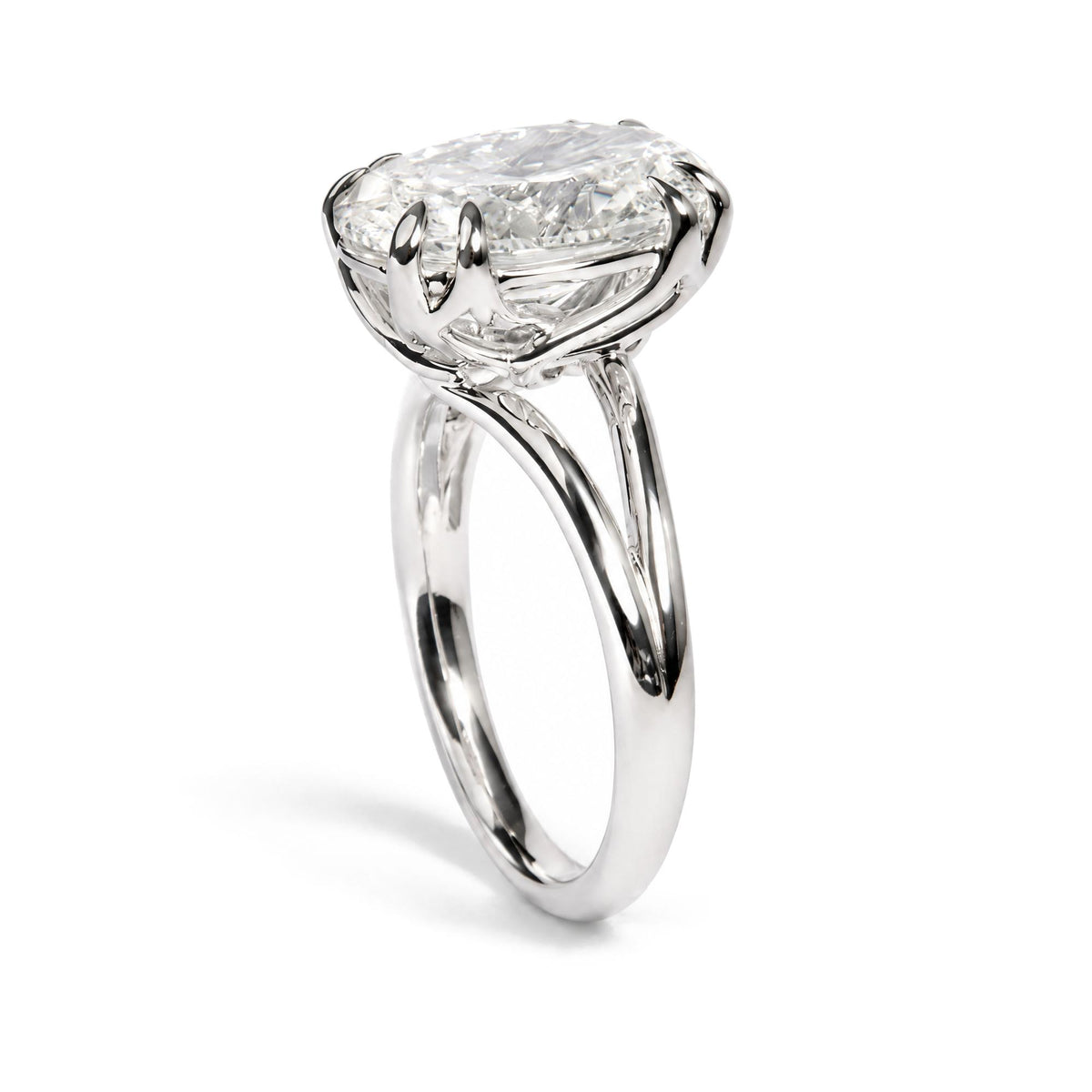 Close-up angled view of a white metal ring featuring an oval-shaped white gemstone held by a double claw prong setting.