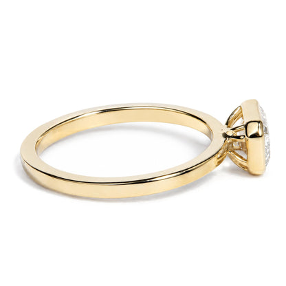 Close-up side-angle view of a yellow metal ring featuring a white emerald-shaped gemstone in a bezel setting.
