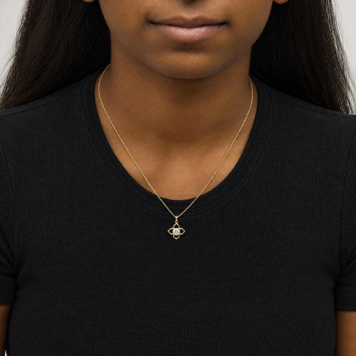 Close-up front view of a model wearing a yellow necklace with a pendant featuring a flower-like design holding one round white gemstone in a bezel setting.