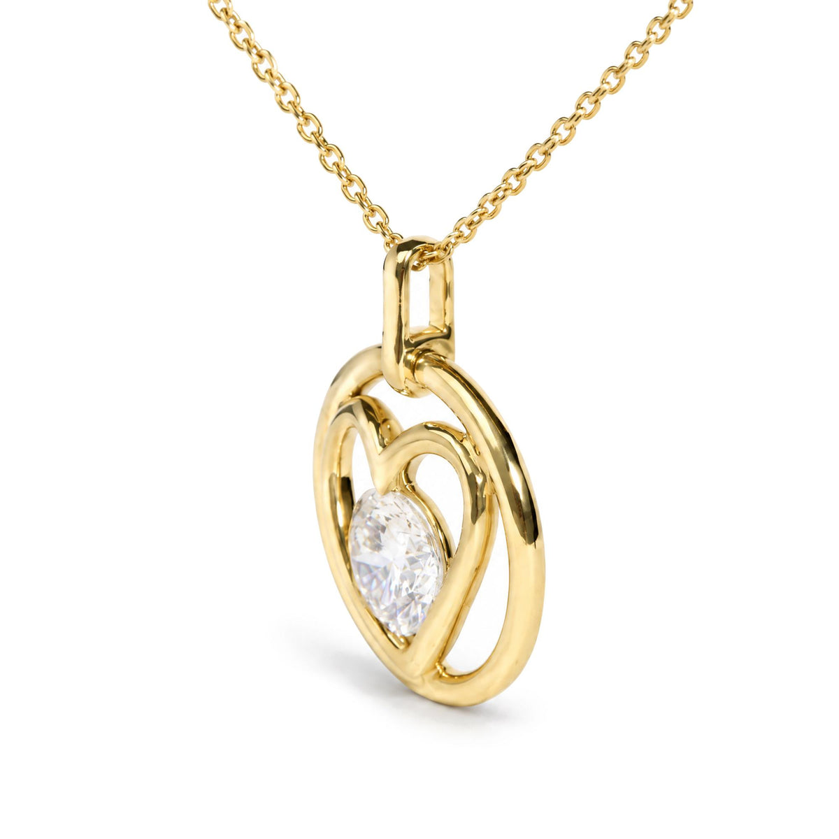 Close-up front angle of yellow metal necklace with an abstract heart-shaped pendant featuring a single round white gemstone in bezel setting.