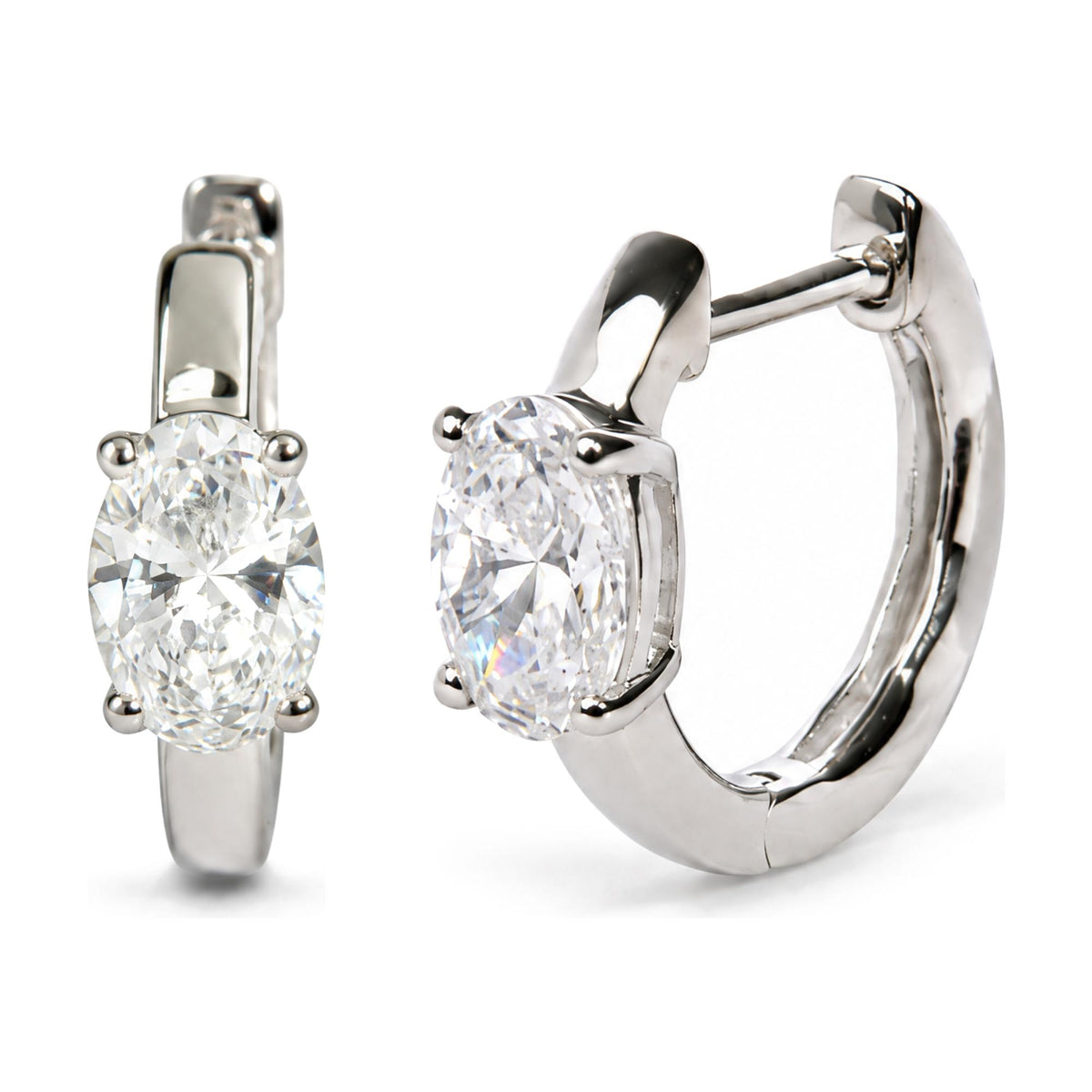 Close-up image of a pair of white metal hoop earrings with oval-shaped white gemstones set in a four-prong setting, shown from a front and side angle on a white background.
