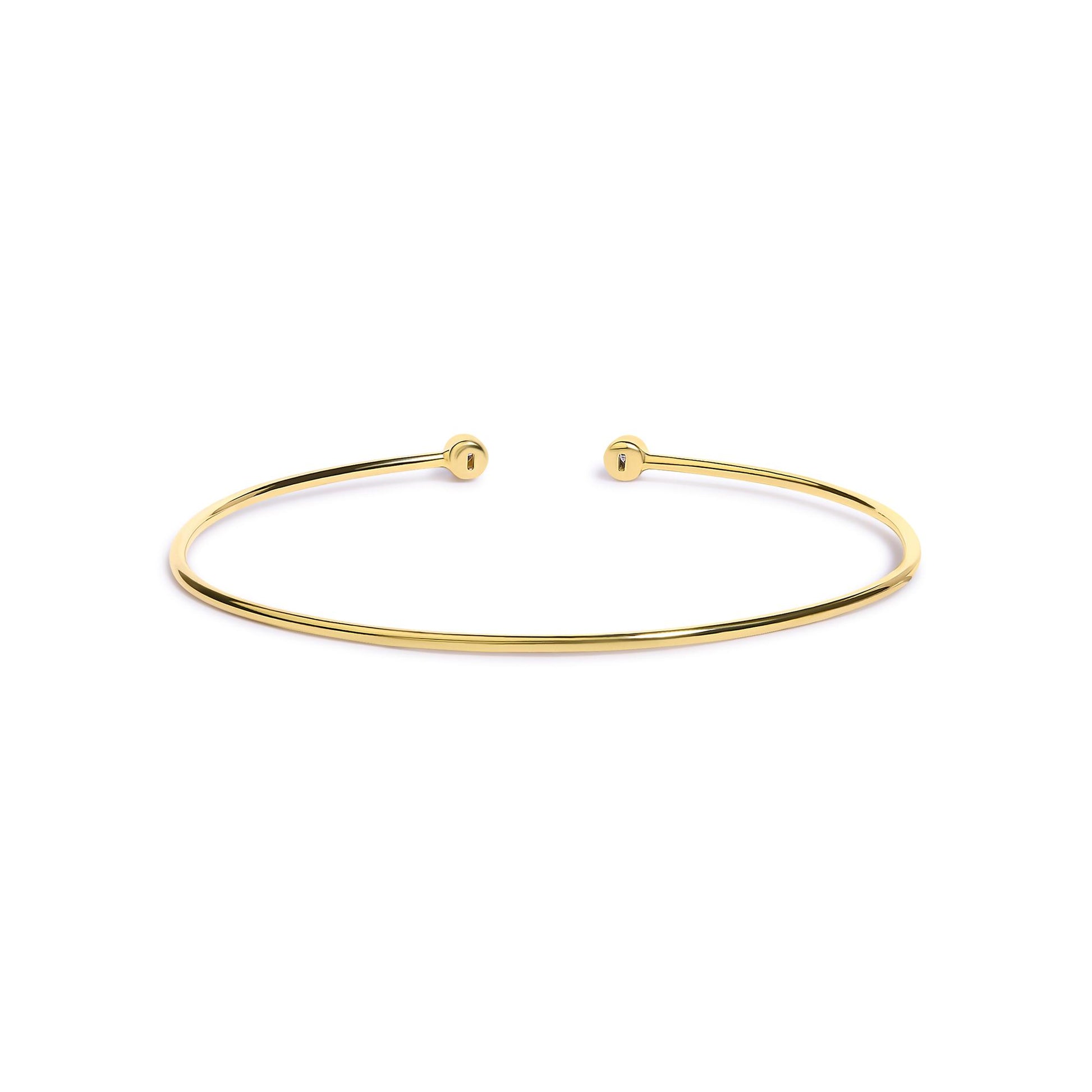 Open-ended thin bracelet in yellow and white metal with round white gemstones in bezel settings at each end, shown from a front angle on a white background.