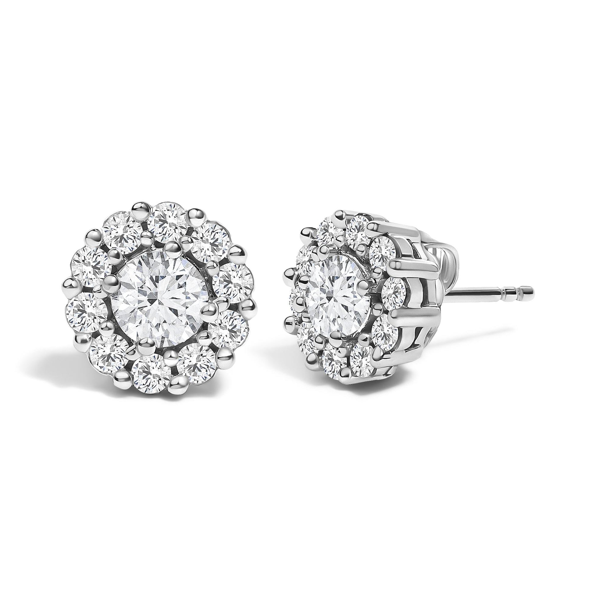 Front and side angled view of white metal stud earrings featuring a central round gemstone in 4-prong setting, surrounded by a cluster of smaller round gemstones in shared prong setting.
