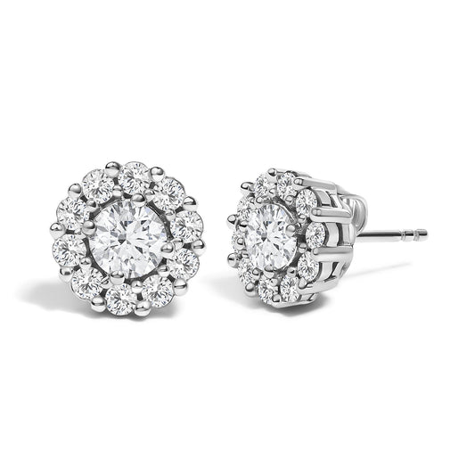 Front and side angled view of white metal stud earrings featuring a central round gemstone in 4-prong setting, surrounded by a cluster of smaller round gemstones in shared prong setting.