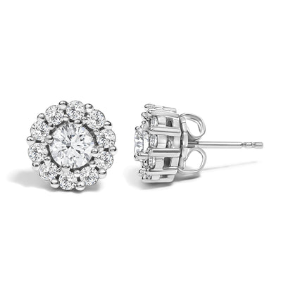Front and side view of round white gemstone stud earrings in white metal with a larger center gemstone in a four-prong setting surrounded by smaller gemstones in a shared prong setting, shown against a white background.