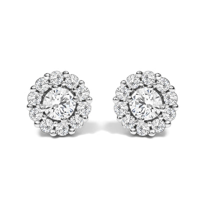 Pair of round white metal stud earrings with a central round white gemstone in four-prong setting, surrounded by smaller round white gemstones in shared prong setting, shown from the front angle on a white background.