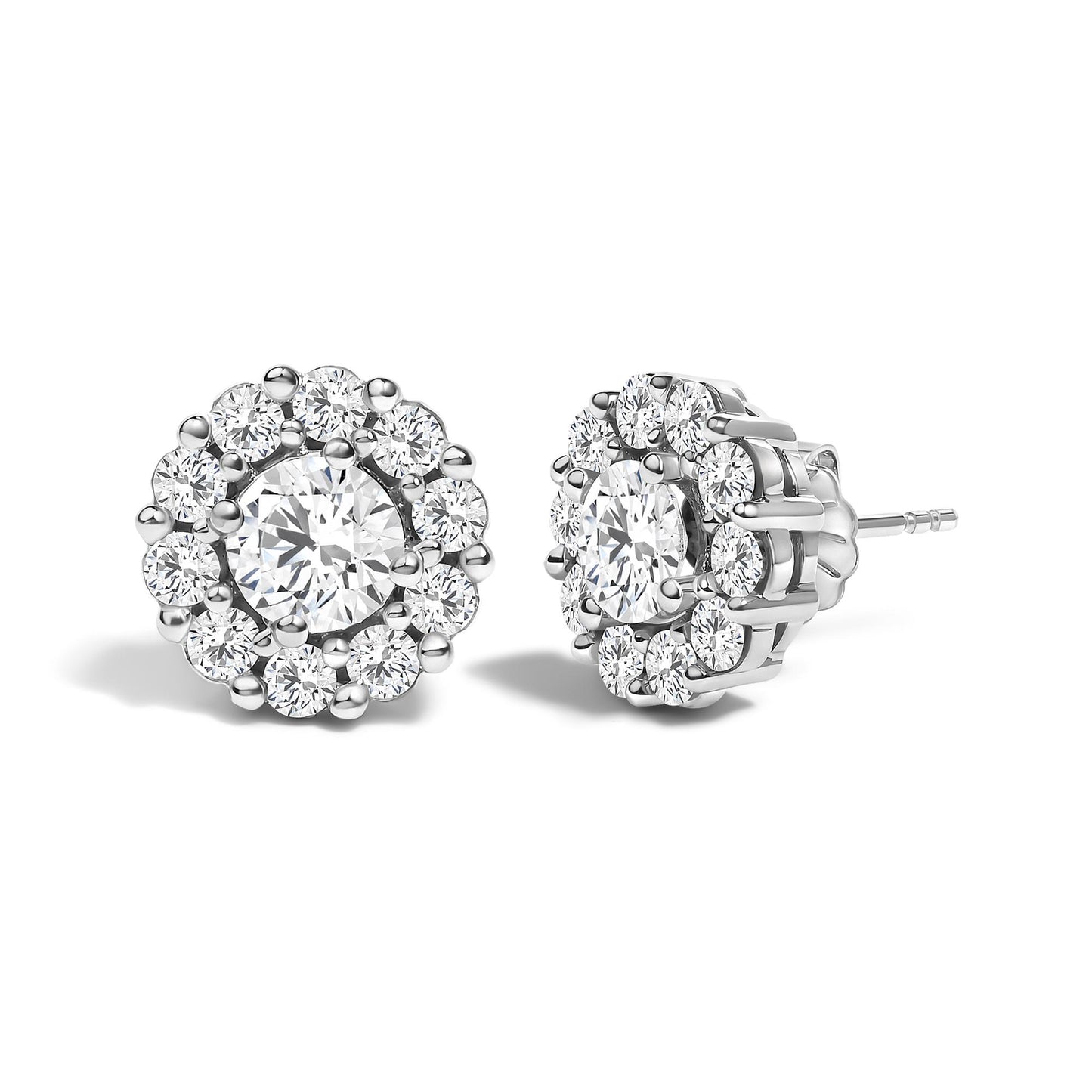 Pair of white metal stud earrings with a central round white gemstone in four-prong setting, surrounded by smaller round white gemstones in shared prong setting, shown from a front and side angle on a white background.