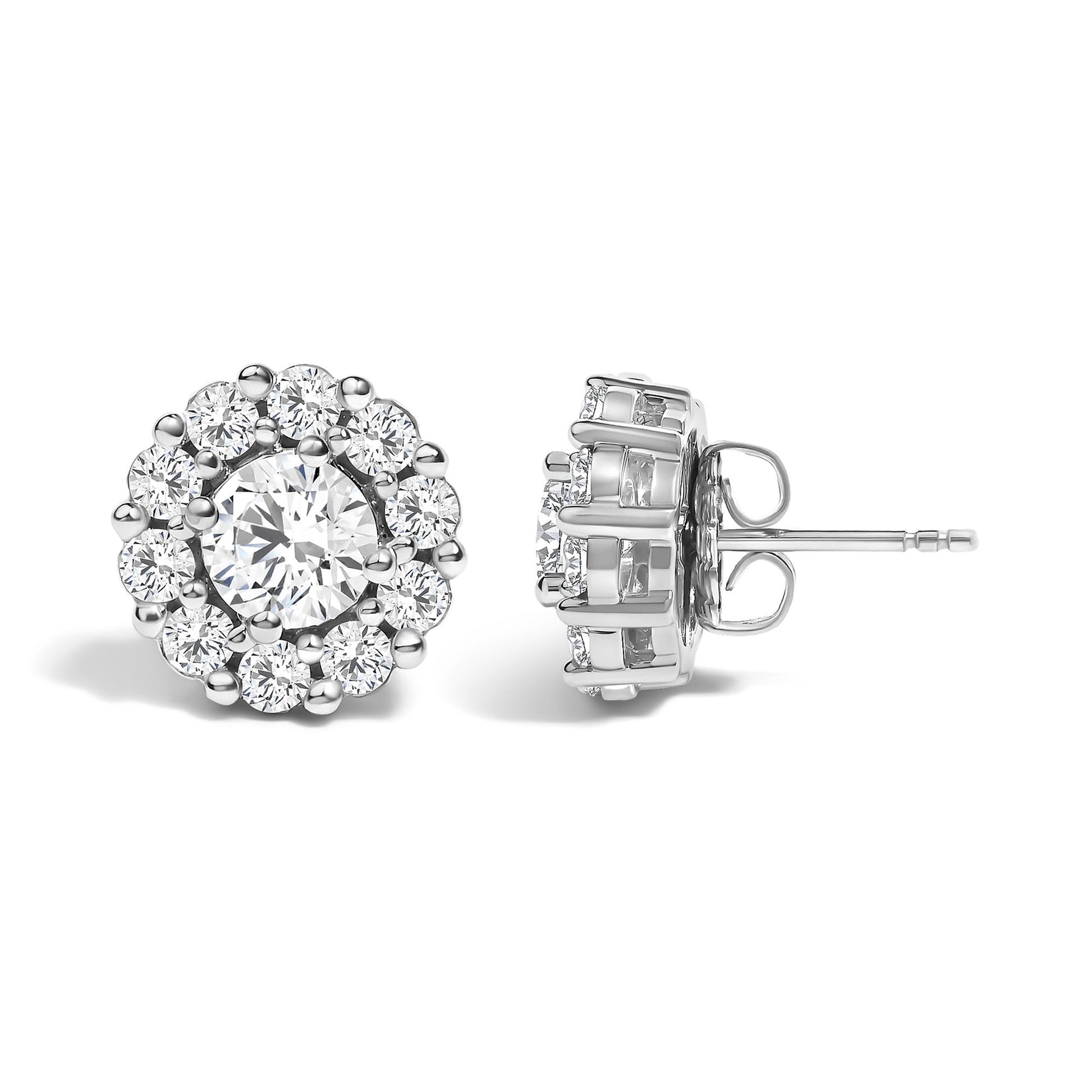 Close-up front and side view of white metal round stud earrings featuring a large round white gemstone in a four-prong setting surrounded by smaller round white gemstones in a shared prong setting.