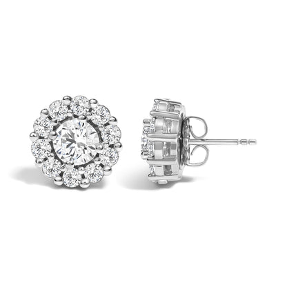 Close-up front and side view of white metal round stud earrings featuring a large round white gemstone in a four-prong setting surrounded by smaller round white gemstones in a shared prong setting.