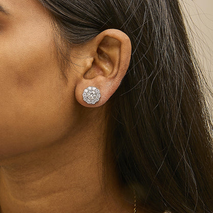 Close-up side view of a model wearing white metal stud earrings featuring a cluster of round white gemstones in 4-prong and shared prong settings.