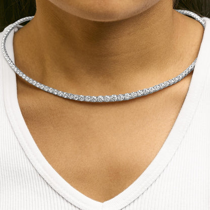 Close-up front view of a white metal necklace featuring two rows of round white gemstones in 4-prong settings, worn on a model.