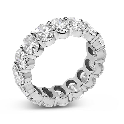Close-up angled shot of a white ring featuring oval-shaped white gemstones in a shared prong setting encircling the band.