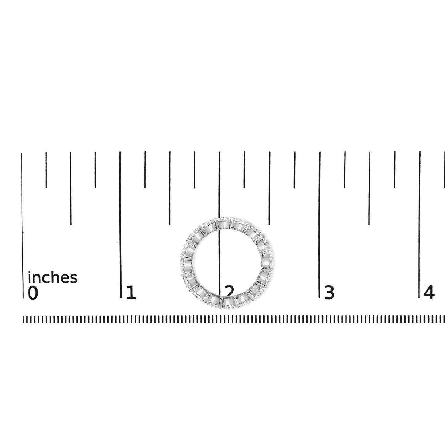 Top-down view of a white ring with oval-shaped white gemstones in a shared prong setting, shown on a ruler scale.