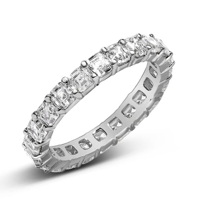 Close-up angled view of a white metal ring featuring a continuous row of asscher-shaped white gemstones in a shared prong setting.