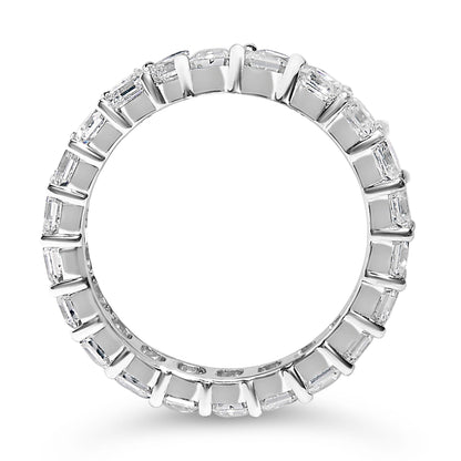 Top-down view of a white metal eternity ring featuring a continuous row of asscher-shaped white gemstones in shared prong settings.