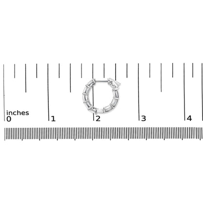 Close-up image of a white metal hoop earring with multiple emerald-shaped white gemstones in a shared prong setting, shown on a measurement scale.