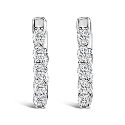 Pair of vertical white metal hoop earrings with oval-shaped white gemstones in a shared prong setting, shown in a front-facing close-up angle on a white background.