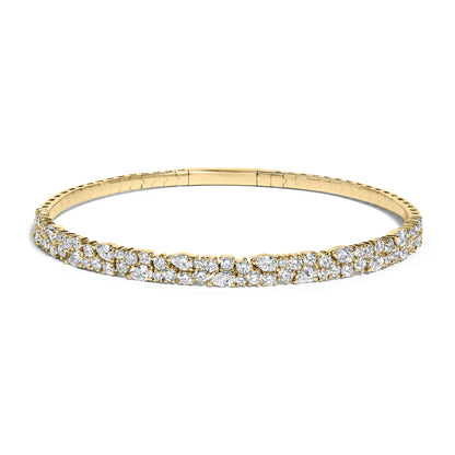 Close-up front view of a yellow metal bracelet adorned with round and pear-shaped white gemstones in prong settings, shown on a white background.