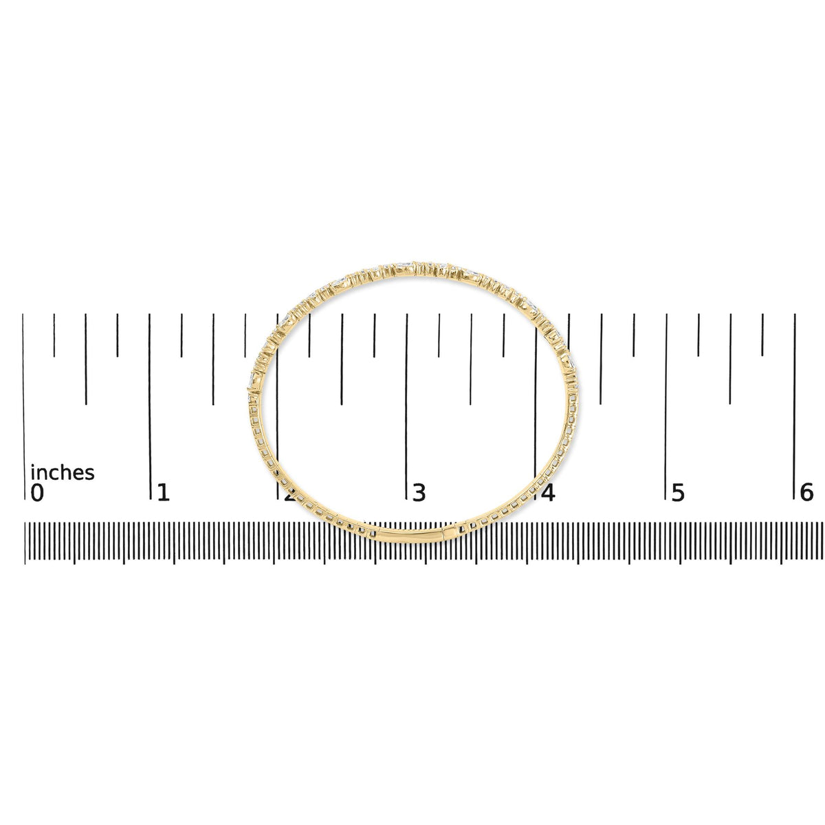Top-down close-up view of a yellow metal bracelet with white pear and round gemstones set along its outer edge, shown on a measurement scale.