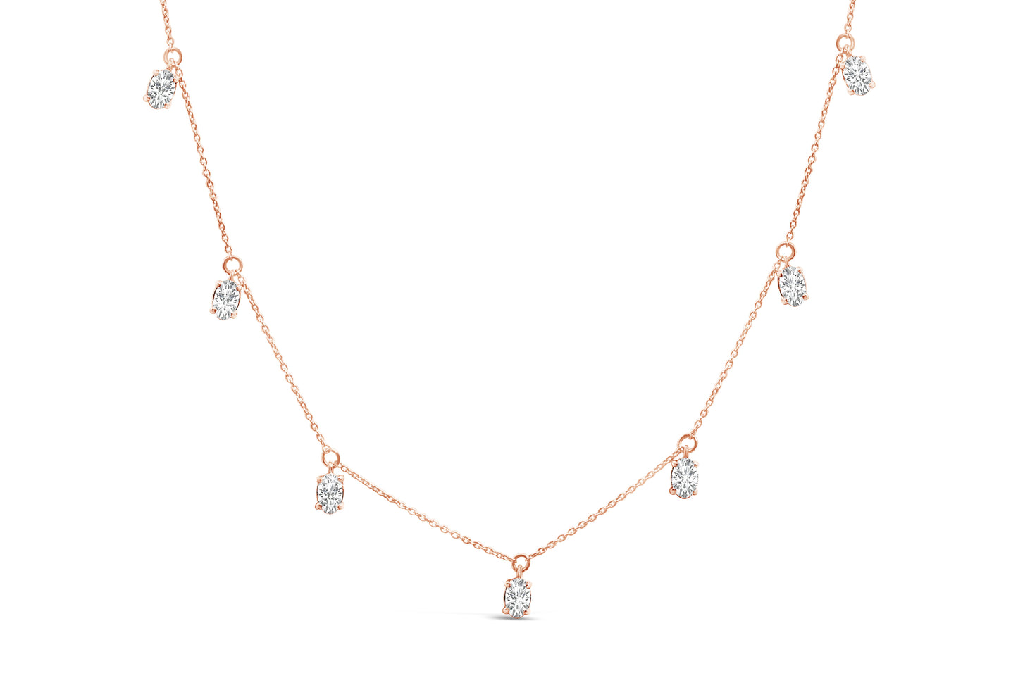Front angle view of a rose-colored necklace featuring seven oval-shaped white gemstones in 4-prong settings evenly spaced along the chain.