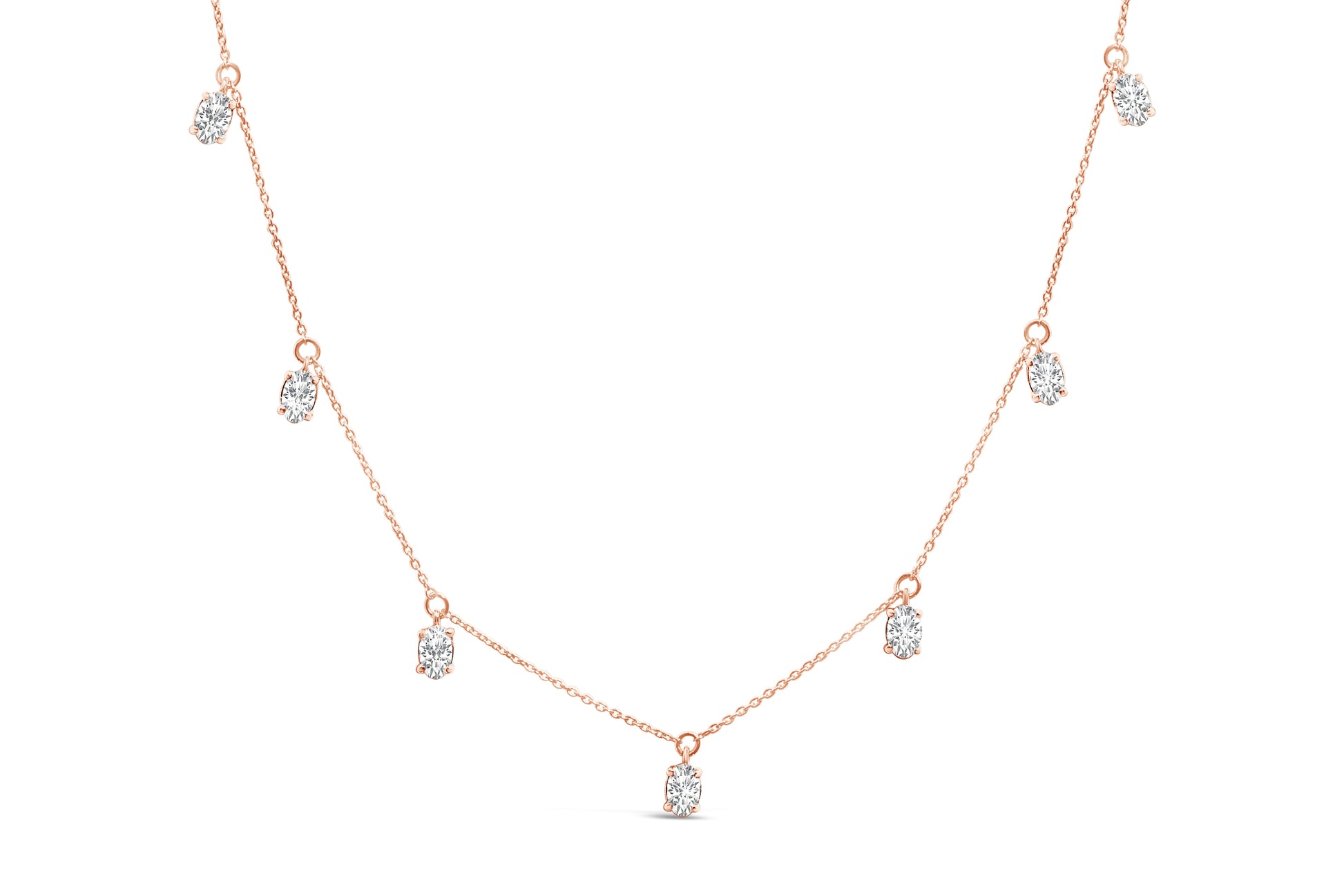 Front angle view of a rose-colored necklace featuring seven oval-shaped white gemstones in 4-prong settings evenly spaced along the chain.