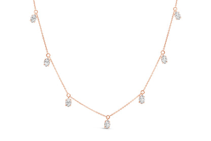 Front angle view of a rose-colored necklace featuring seven oval-shaped white gemstones in 4-prong settings evenly spaced along the chain.