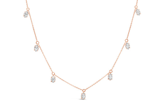 Front angle view of a rose-colored necklace featuring seven oval-shaped white gemstones in 4-prong settings evenly spaced along the chain.