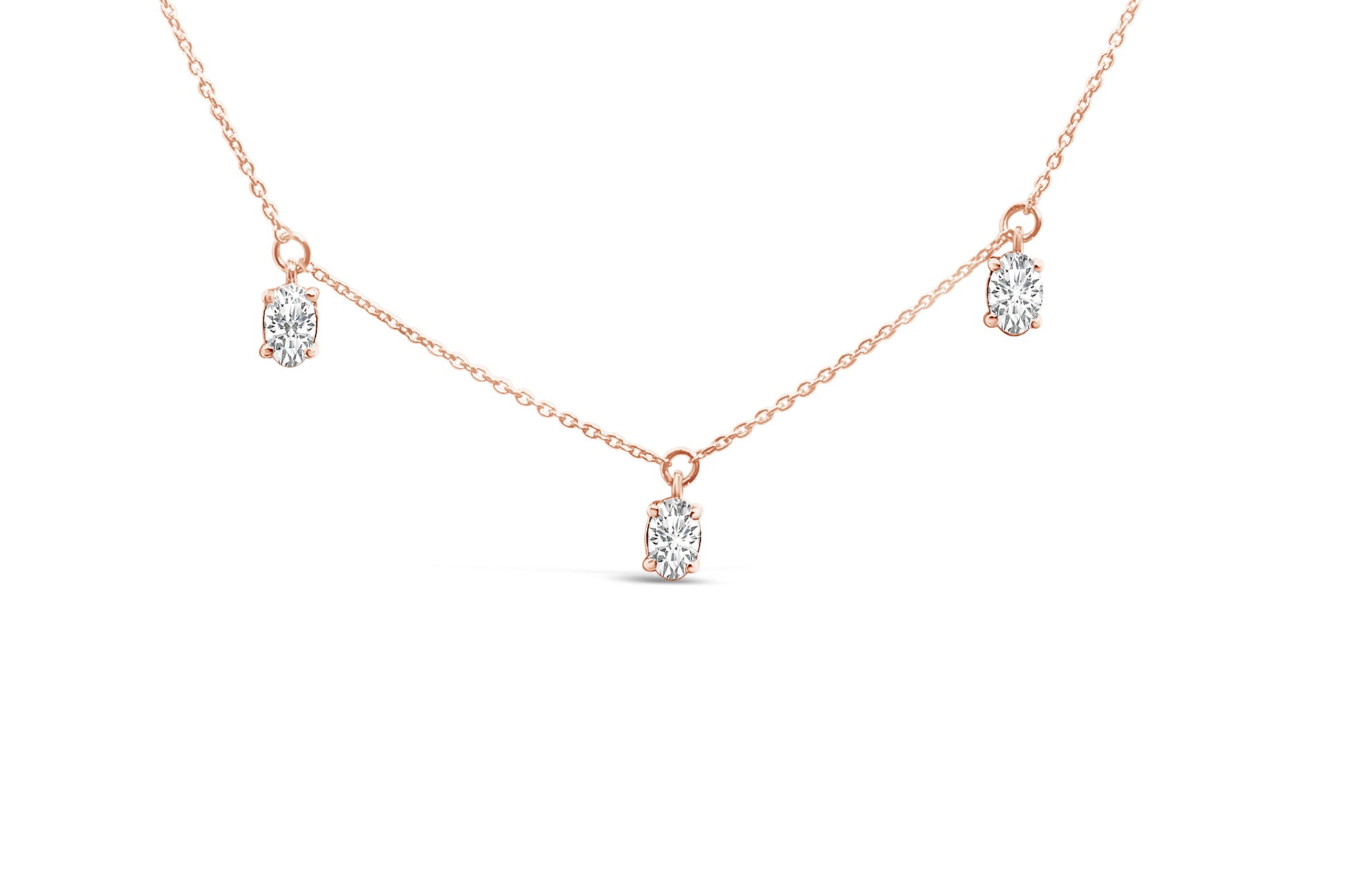 Close-up front view of a rose-colored necklace with three oval-shaped white gemstones in 4-prong settings evenly spaced along the chain.