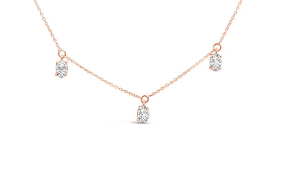 Close-up front view of a rose-colored necklace with three oval-shaped white gemstones in 4-prong settings evenly spaced along the chain.