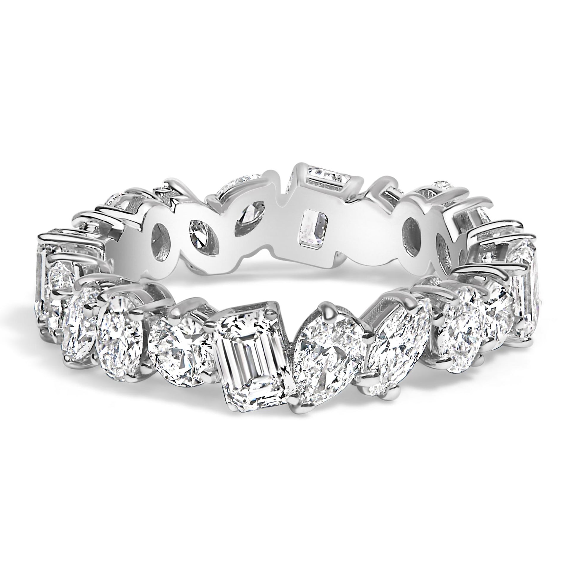 Close-up angled view of a white metal eternity ring featuring an alternating pattern of white gemstones in round, oval, marquise, pear, and emerald shapes, all set with prongs around the band.