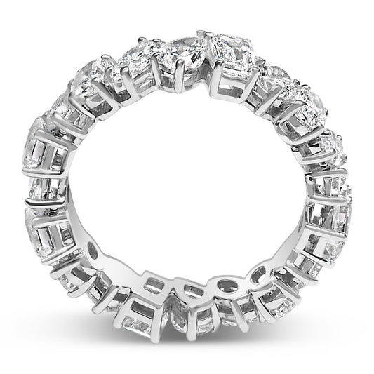 Close-up front angle of a white ring featuring an alternating pattern of round, oval, marquise, pear, and emerald shaped white gemstones set in prongs around the entire band.