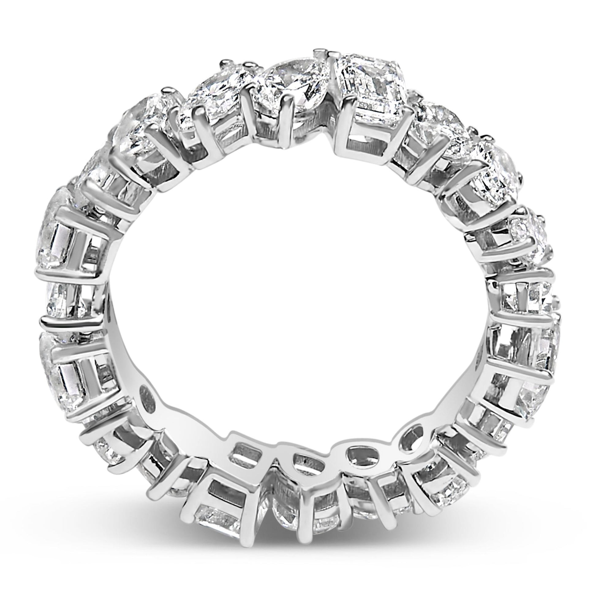 Close-up front angle of a white metal eternity ring featuring an alternating pattern of oval, pear, round, marquise, and emerald shaped white gemstones in prong settings.