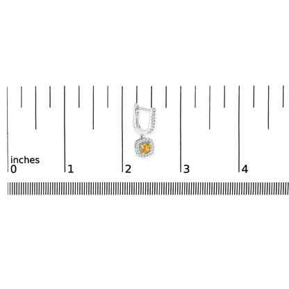 Single white metal earring with a yellow cushion-shaped gemstone surrounded by small round white gemstones, shown on a scale from a top-down angle.