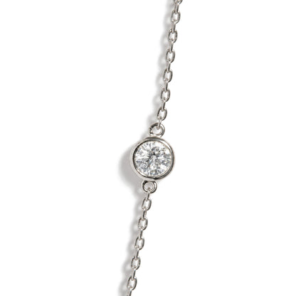 Close-up top angle view of a white metal necklace chain featuring a round white gemstone in a bezel setting.