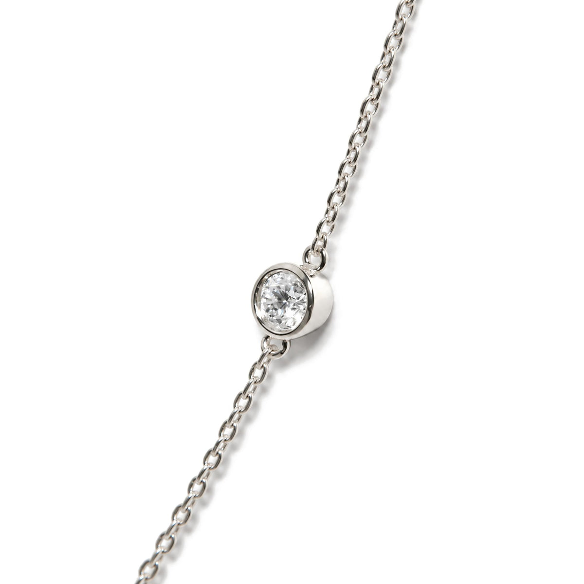 Close-up angled view of a white necklace chain with a round white gemstone in bezel setting.