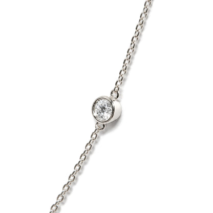 Close-up angled view of a white necklace chain with a round white gemstone in bezel setting.
