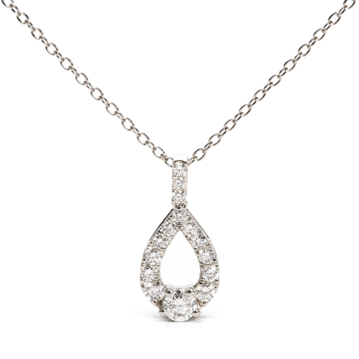 Close-up front view of a white necklace chain with a teardrop-shaped pendant encrusted with round white gemstones in prong settings, shown on a white background.