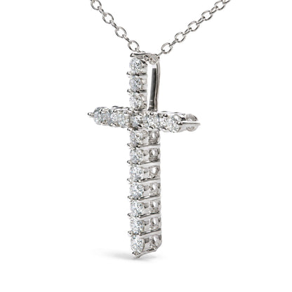 Close-up front angle of a white metal cross-shaped necklace pendant with round white gemstones in prong settings, shown on a white background.