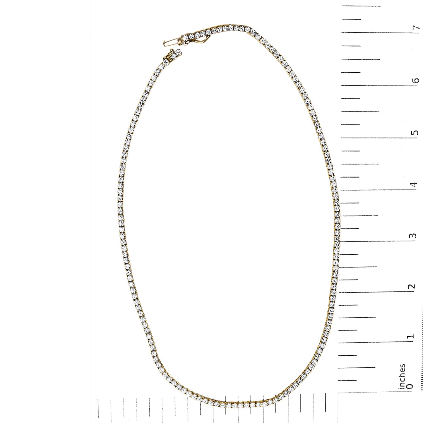 Yellow metal necklace with round white gemstones in a 4-prong setting, shown flat on a scale with rulers.