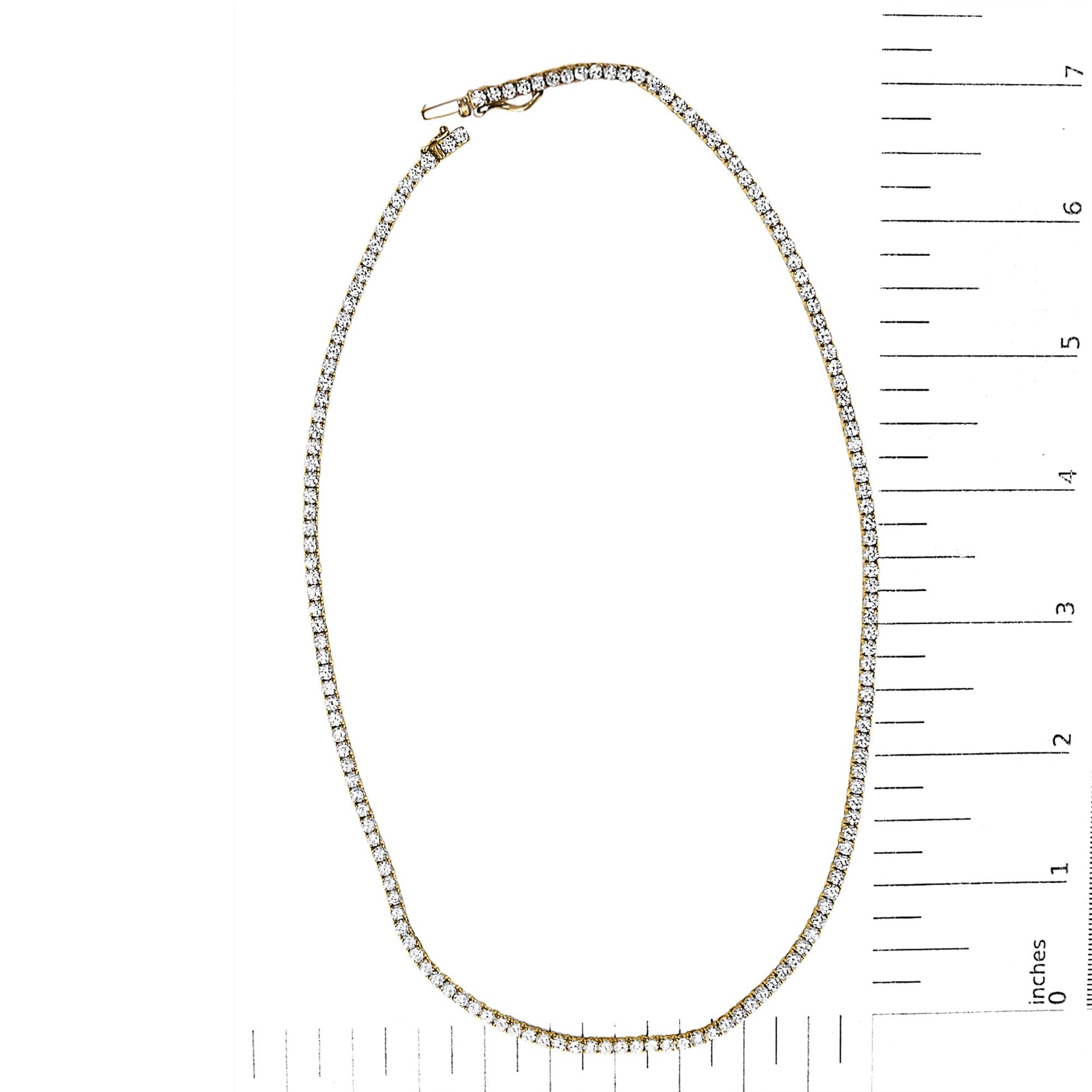 Yellow metal necklace with round white gemstones in a 4-prong setting, shown flat on a scale with rulers.