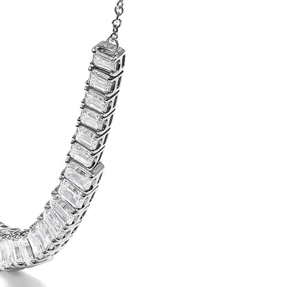 Close-up angled view of a white necklace featuring a curved row of emerald-shaped white gemstones in four-prong settings.