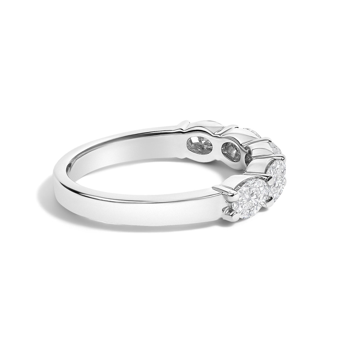 Close-up side angled view of a white ring featuring five oval-shaped white gemstones set in shared prong settings.