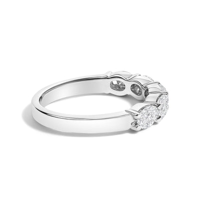 Close-up side angled view of a white ring featuring five oval-shaped white gemstones set in shared prong settings.