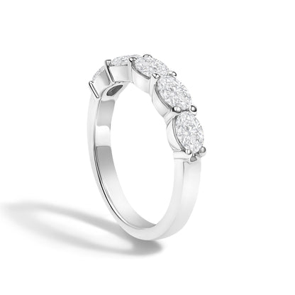 Close-up angled view of a white metal ring featuring five oval-shaped white gemstones in a shared prong setting.