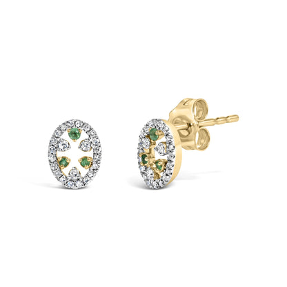 Close-up front and side angle of oval yellow metal stud earrings with small round white gemstones surrounding inner space adorned with green round gemstones, showing front design and post.