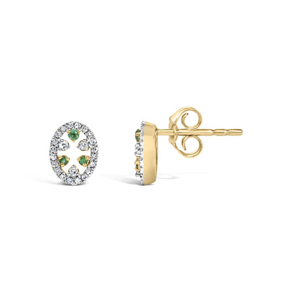 Close-up front and side view of oval-shaped yellow metal stud earrings featuring round white gemstones surrounding green gemstones in a prong setting.