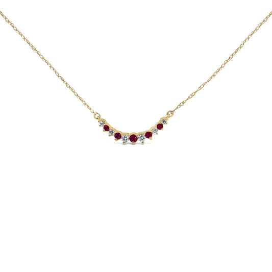 Close-up front angle of a yellow metal necklace with alternating round white and red gemstones in prong settings, shown on a white background.