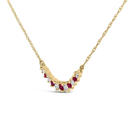 Close-up front angle of a yellow metal necklace with a V-shaped pendant featuring alternating round red and white gemstones in prong settings.