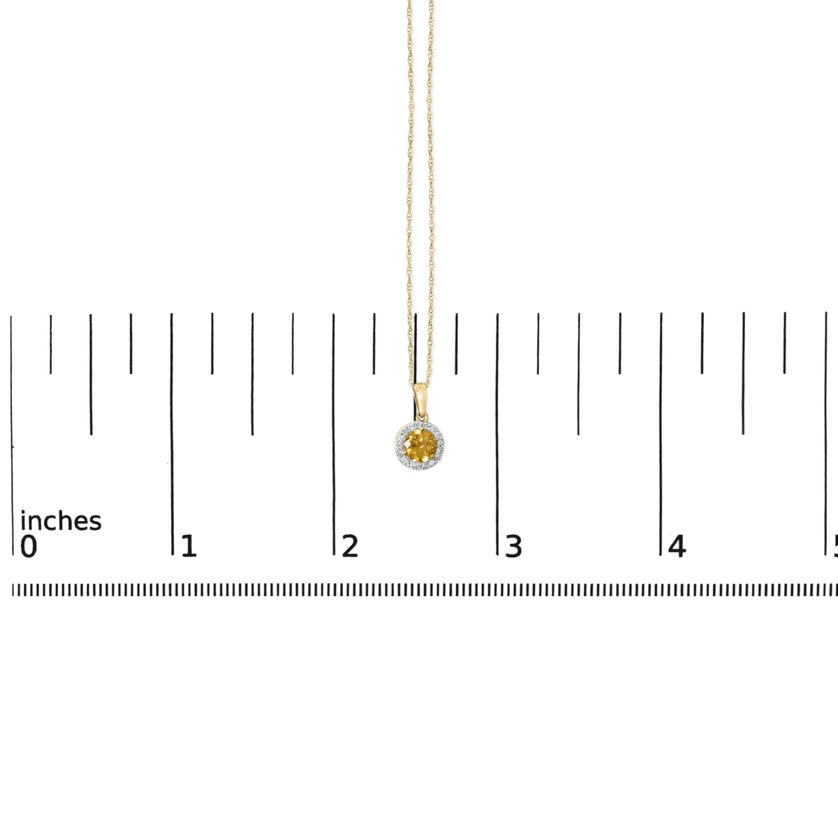 Close-up image of a yellow metal necklace with a round yellow gemstone pendant surrounded by smaller white gemstones, shown on a scale.