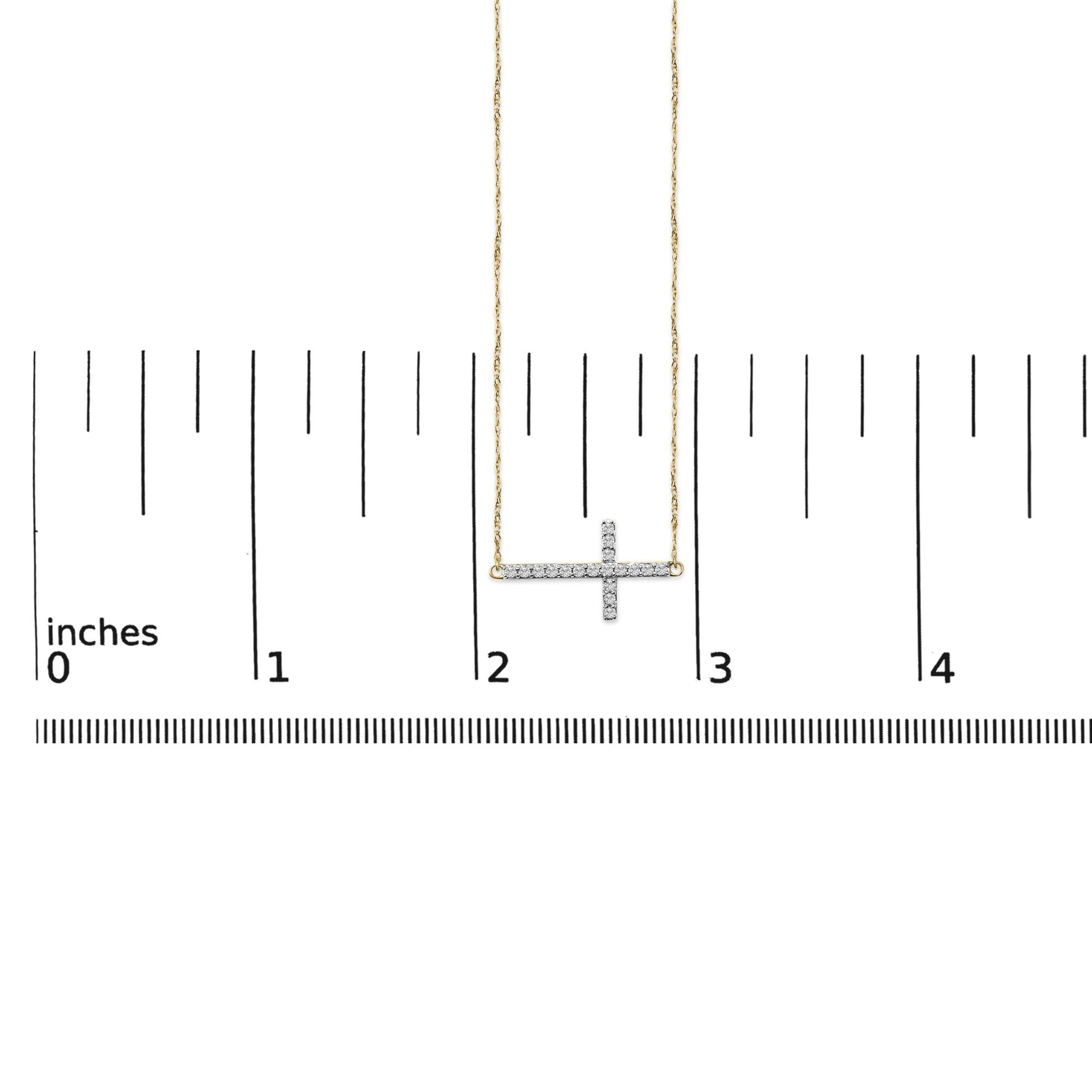 Necklace with a horizontal cross pendant set with round white gemstones in shared prong setting, shown on a scale from a front angle.